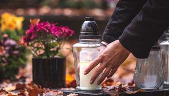 Placing-candle-on-grave.jpg?sw=336&cx=0&cy=283&cw=5589&ch=3161&q=60